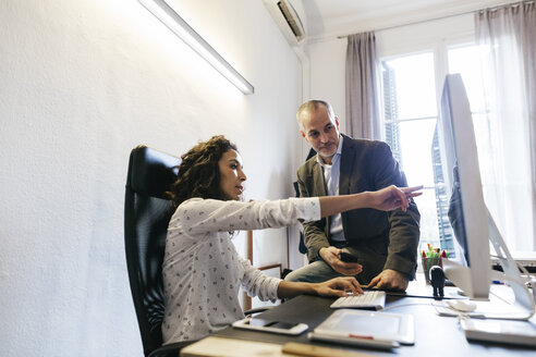 Geschäftsmann und Frau im Büro arbeiten zusammen am Computer - EBSF01880