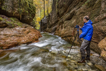 Österreich, Tennegau, Fotograf am Fluss Taugl stehend - YRF00144