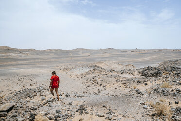 Marokko, Merzouga, Frau geht durch die Steinwüste - KIJF00996