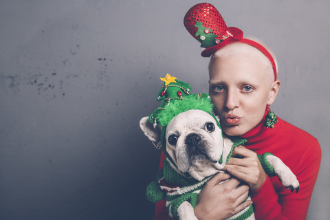 Porträt einer Frau und ihrer französischen Bulldogge zur Weihnachtszeit, lizenzfreies Stockfoto