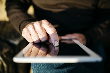 Man's forefinger touching display of tablet, close-up - JRFF01071