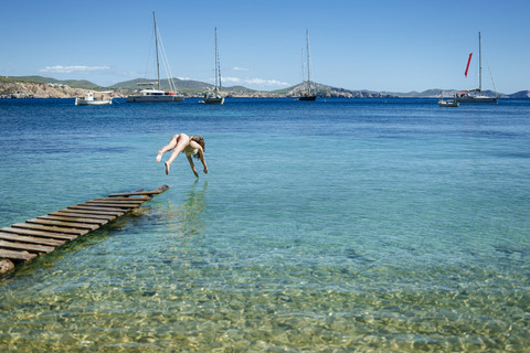 Spian, Ibiza, Frau im Bikini springt vom Steg, lizenzfreies Stockfoto