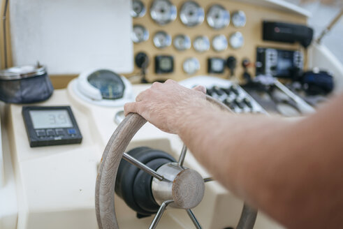 Man steering motor boat, close up - KIJF01028