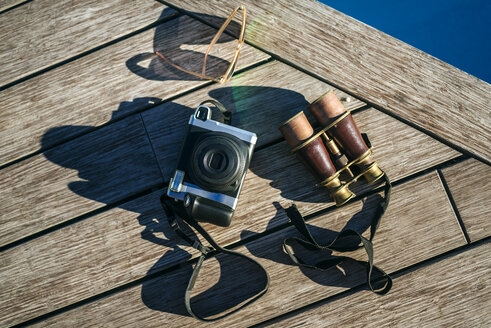Fernglas, Kamera und Sonnenbrille auf Holz - KIJF01033