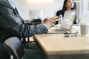 Businessman sitting in meeting, using laptop - EBSF01969