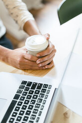 Woman in office holding cup of coffee - EBSF01990