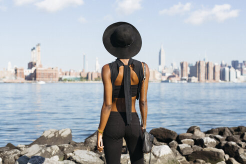 USA, New York City, Brooklyn, junge Frau steht am East River - GIOF01646