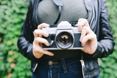 Woman's hands holding analogue camera, close-up stock photo