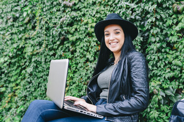 Young woman using laptop outdoors - GEMF01289