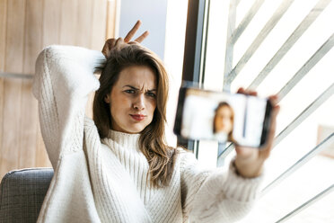 Verspielte junge Frau macht ein Selfie mit Handy - VABF00874