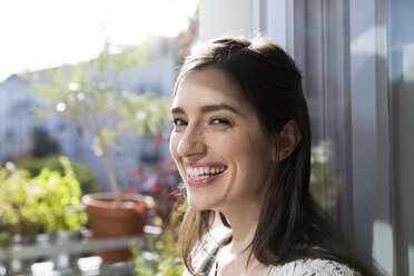 Portrait of happy woman at the window - FKF02117