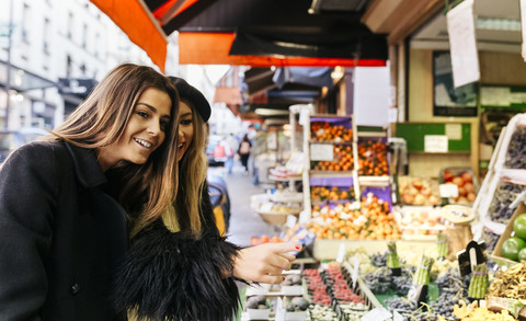 France, Paris, two young women at a street market in Montmartre stock photo