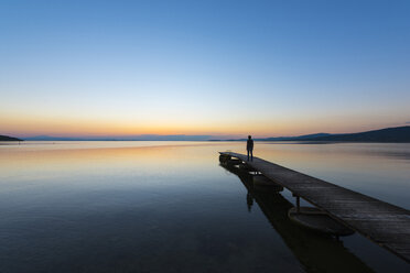 Italien, Umbrien, Trasimeno-See, Silhouette eines Mannes auf einem Steg bei Sonnenuntergang - LOMF00451