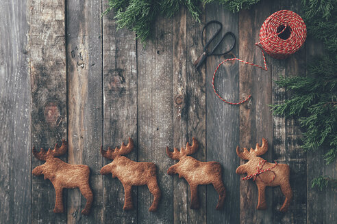 Row of four Elk-shaped Christmas cookies on dark wood - RTBF00549