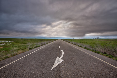 Spanien, Provinz Zamora, leere Straße unter bewölktem Himmel, lizenzfreies Stockfoto