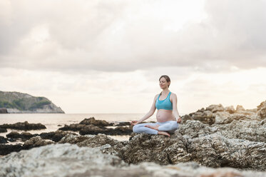 Pregnant woman practising yoga at the sea - DIGF01465