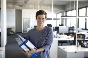 Businesswoman in office holding folders - RBF05231