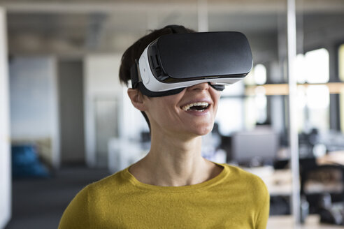 Glückliche Frau im Büro mit Virtual-Reality-Brille - RBF05239
