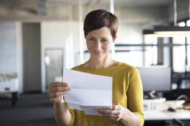 Businesswoman in office looking at paper - RBF05242