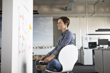 Businesswoman in office looking at mind map - RBF05251