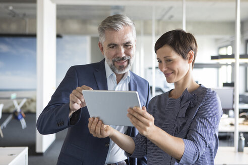 Businessman and businesswoman with tablet in office - RBF05281