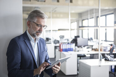 Businessman in office using tablet - RBF05292