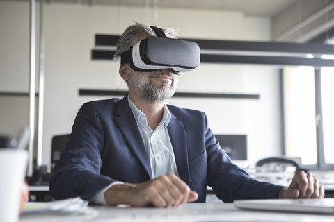 Businessman in office wearing virtual reality glasses stock photo