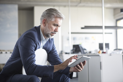 Geschäftsmann benutzt Tablet im Büro, lizenzfreies Stockfoto