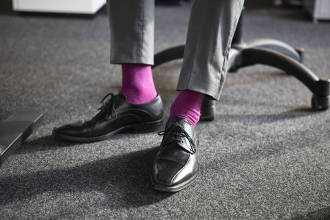 Nahaufnahme eines Geschäftsmannes im Büro mit rosa Socken, lizenzfreies Stockfoto