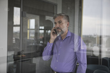 Geschäftsmann im Büro am Mobiltelefon - RBF05333