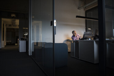 Exhausted businessman sleeping at office desk - RBF05334