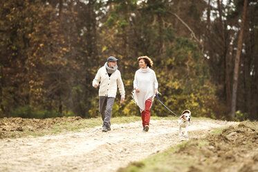 Senior couple walking in the woods with her dog - HAPF01152