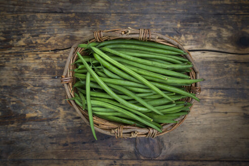 Wickerbasket of green beans on dark wood - LVF05640