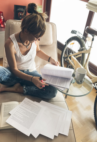 Frau arbeitet zu Hause an einem Drehbuch, lizenzfreies Stockfoto