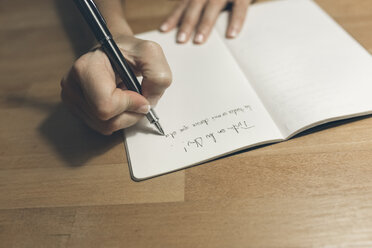 Woman writing in notebook with a classic fountain pen - MGOF02684