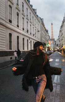 Frankreich, Paris, junge Frau auf der Straße mit dem Eiffelturm im Hintergrund - MGOF02688