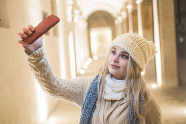 Portrait of young woman wearing wololy hat taking selfie with cell phone - SIPF01149