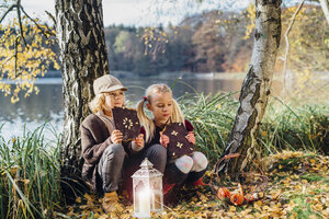 Hänsel und Gretel, Junge und Mädchen sitzen im Wald und essen Lebkuchen - MJF02094