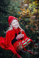 Little imp sitting in forest, holding fly agaric - MJF02108