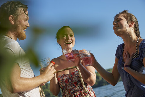 Glückliche Freunde in einem See beim Trinken - FMKF03283