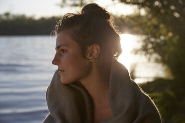 Junge Frau an einem See bei Sonnenuntergang - FMKF03289