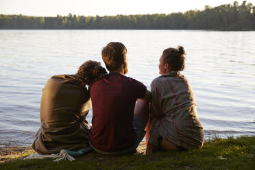 Friends sitting at a lake - FMKF03292