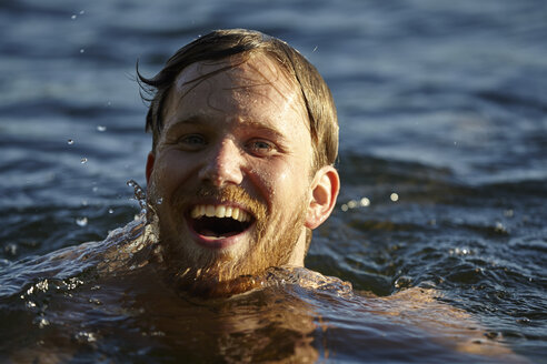 Glücklicher junger Mann in einem See - FMKF03302