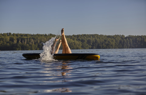 Zwei Frauen springen vom Paddelbrett ins Wasser, lizenzfreies Stockfoto