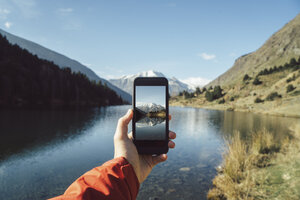 Frankreich, Pyrenäen, Pic Carlit, Mann beim Fotografieren am Bergsee - KKAF00159