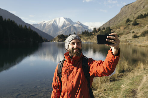 France, Pyrenees, Pic Carlit, hiker taking a selfie at mountain lake - KKAF00162