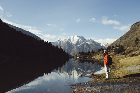 France, Pyrenees, Pic Carlit, hiker taking a rest at mountain lake stock photo