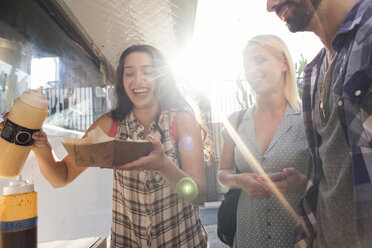 Happy friends with takeaway food outdoors - WEST22147