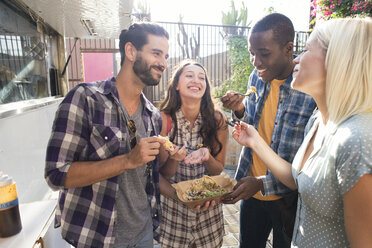 Happy friends sharing takeaway food outdoors - WEST22152