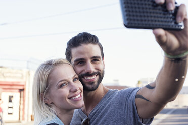 Happy young man with girlfriend taking a selfie - WEST22160